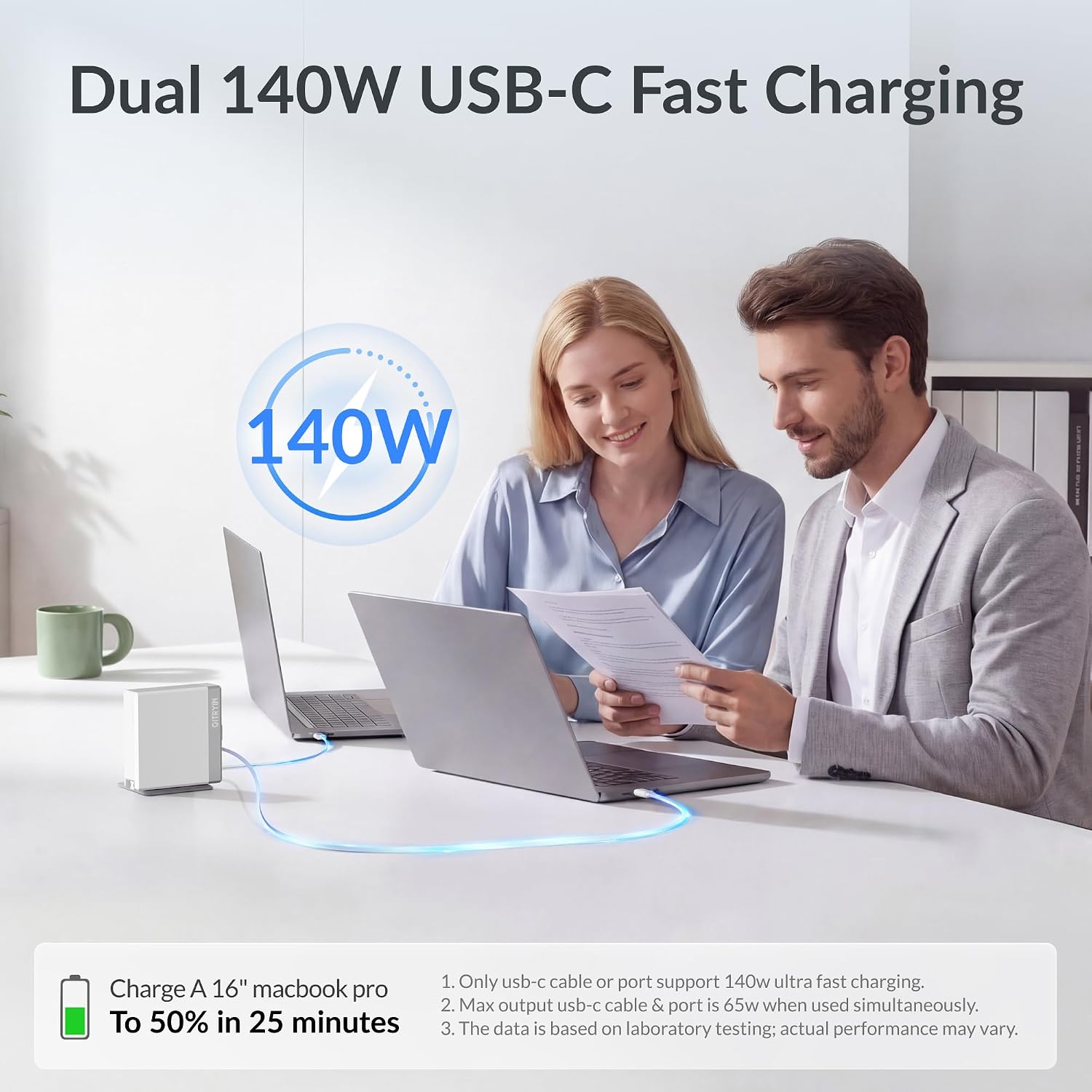 [Color] compact 140W retractable laptop charger with dual USB-C ports and coiled cable, displayed with MacBook and iPhone — view 2