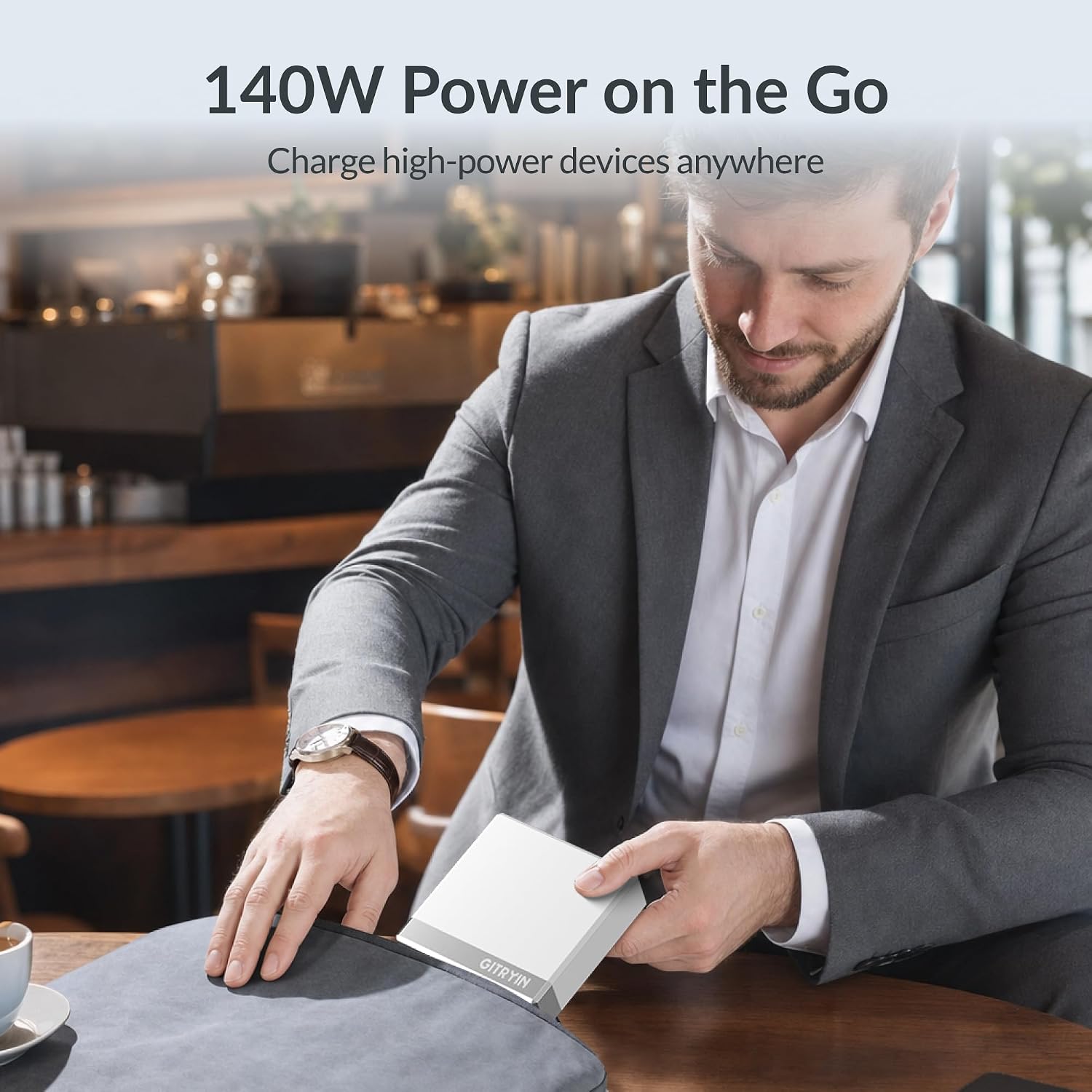[Color] compact 140W retractable laptop charger with dual USB-C ports and coiled cable, displayed with MacBook and iPhone — view 4